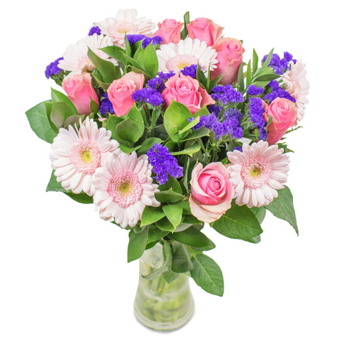 This vivid, thoughtfully crafted bouquet-created by a seasoned Dartmount Park florist-features an artful blend of approximately 7-9 medium pink roses with tightly coiled or softly opened petals, their spiral forms inviting the eye. These romantic blooms are nestled beside 5-7 pastel pink Gerbera daisies, each head wide and cheerful, flaunting a subtle ombre fade towards nearly white centres. Among the roses and gerberas, lively bundles of purple statice burst with colour, their papery florets adding a textured, sculptural layer reminiscent of Dartmount Park's natural landscapes. The greens are lush, layered, and verdant, providing a feeling of abundance and referencing the area's tree-lined avenues. Arranged in a tall, clear vase that reveals fresh-cut stems bathed in clean water, the composition suggests both freshness and approachability. This bouquet, available for prompt delivery through Flower Delivery Dartmouth Park, is ideally suited for birthdays, anniversaries, Mother's Day, or to brighten a local practice or artist's home. Radiating warmth and celebratory joy, its combination of blooms and tactile detail conveys affection while subtly honouring the beauty and diversity of Dartmount Park.