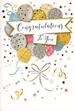 The photograph features a single congratulations card propped up as though waiting to accompany a celebratory bouquet delivered somewhere along York Rise or Chester Road in Dartmouth Park. The card's design is a joyful tangle of balloons and ribbons, rendered in a palette that mixes soft metallics with modern pastels. Rounded balloons in gold, silver, champagne, light blue, blush pink, and quiet grey rise from the lower portion of the card, layered one in front of another to create the sense of a full, generous cluster. Each balloon is subtly different: some are dusted with delicate glitter, others scattered with tiny stars or patterned with gentle stripes, all suggesting shimmer and depth without overwhelming the eye. Fine, curling strings in gold and silver trail downward and wind around each other, giving the impression that the balloons are lightly tethered, ready to drift higher at any moment. Crossing the middle of this floating arrangement is a soft, ribbon-like banner bearing the words Congratulations To You in an elegant, flowing script, the kind you might find on a carefully written note of thanks or praise. Small metallic stars, dots of confetti, and whimsical swirls are sprinkled across the surrounding space, dancing over a pale, unobtrusive background that keeps the design feeling airy and spacious. The overall impression is one of light-hearted festivity and heartfelt admiration, echoing the feeling of sending flowers and a card after hearing about a new job, an exam success, or a milestone birthday. Though the card is simple in structure-just paper, ink, and shimmering accents-the thoughtful composition and harmonious colours make it feel like a keepsake of a proud, joyful moment.